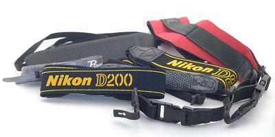 Eine ganze Sammlung unterschiedlicher Kameratragegurte: Canon, Nikon, OP/tech, UPstrap